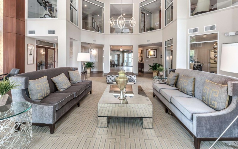 Bright clubhouse with high ceilings and couches at Deerwood Apartments, one of our Houston, Texas apartments for rent.