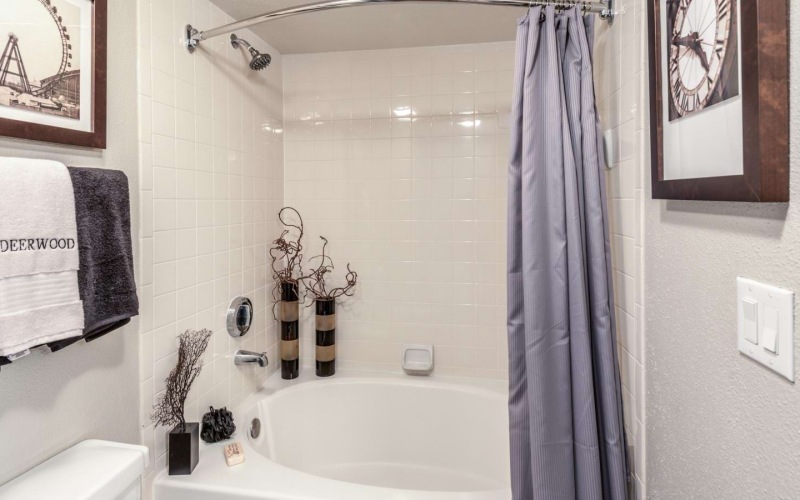 Bathroom with a shower and tub combination at Deerwood Apartments, among our apartments in Houston with a balcony and modern finishes.
