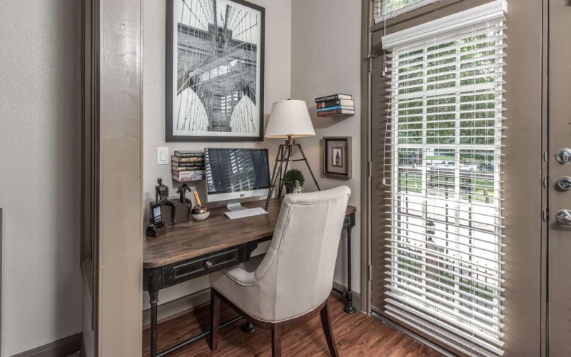 Home work space beside french doors in one of our apartments in Houston with a balcony at Deerwood Apartments.